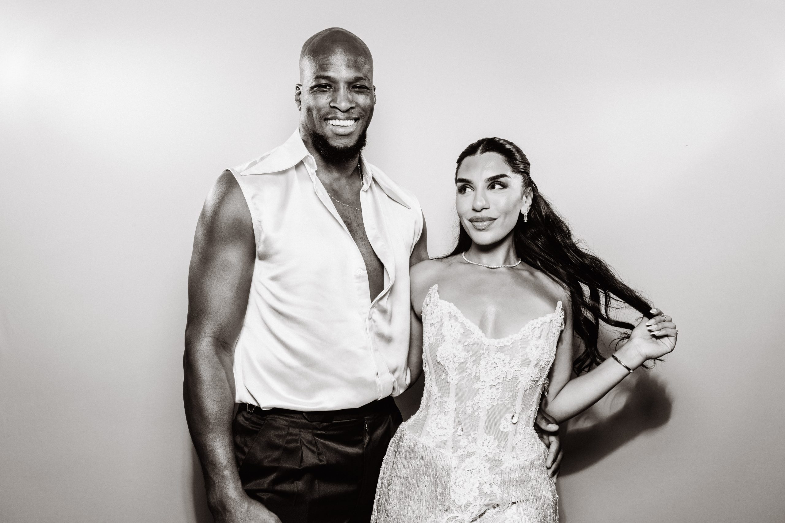 Booth print of a man in an open white shirt and a woman in a sparkly dress posing together